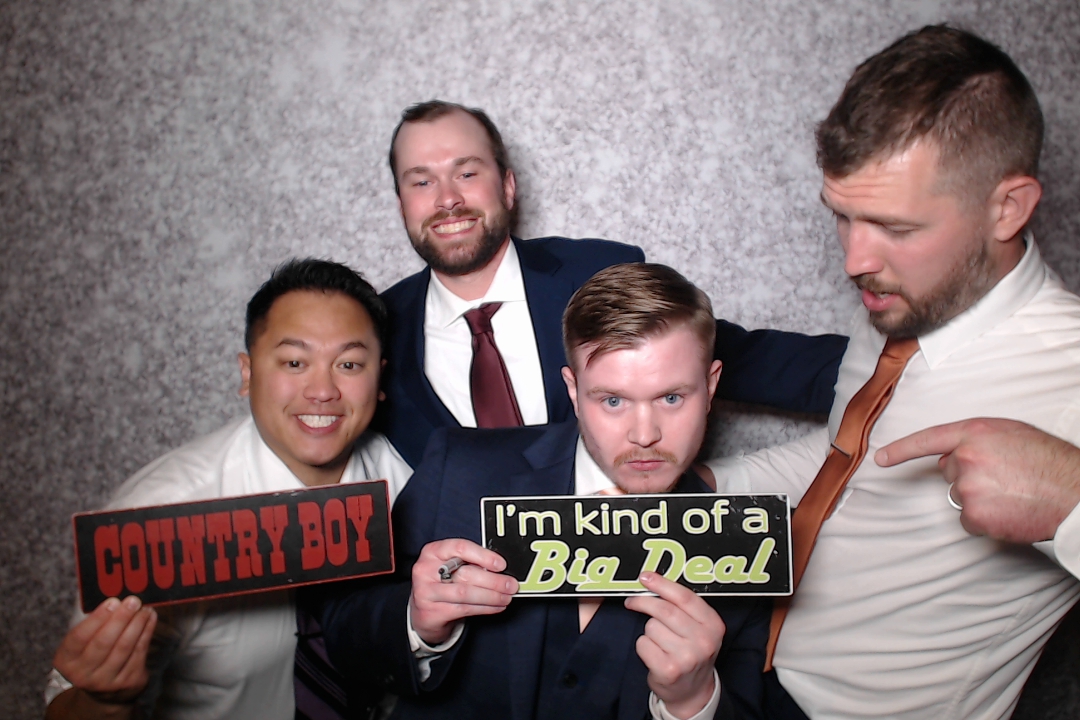 Four guests holding props in an Absolute Music photo booth