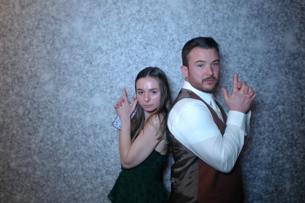 Couple making hand hearts in the photo booth