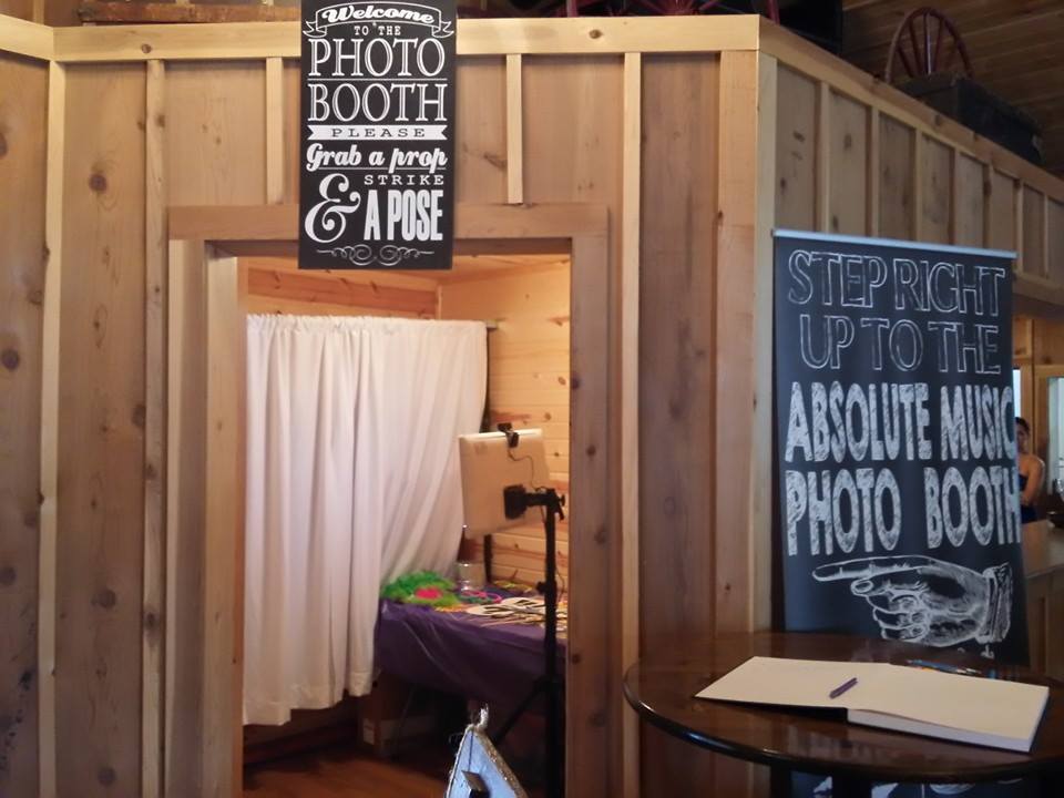 Absolute Music photo booth with white curtains, props and welcome signs