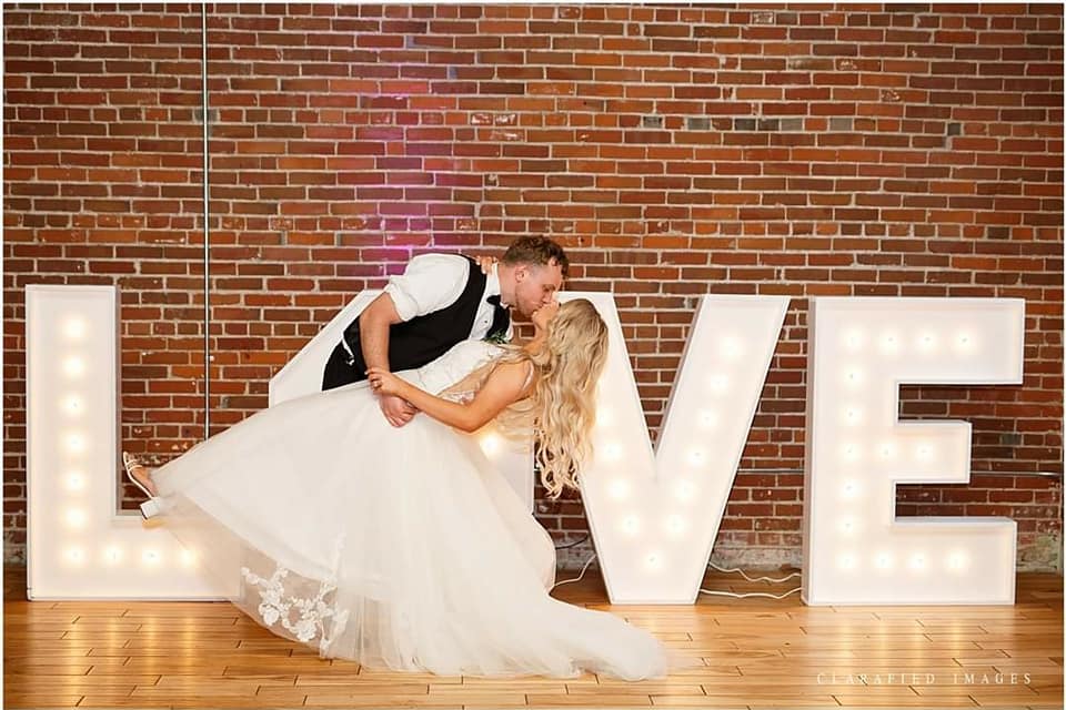 Wedding couple with illuminated LOVE letters at the former Millwork Ballroom