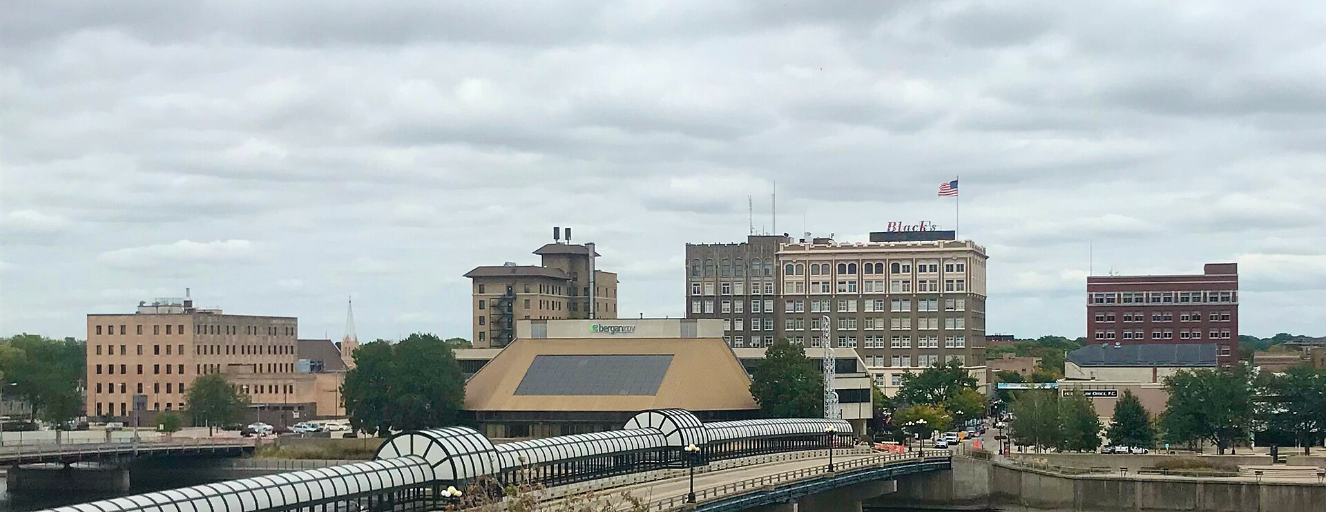 Downtown Waterloo skyline and covered pedestrian bridge over the Cedar River